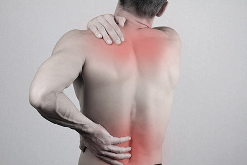 Man with neck and back pain. Man rubbing his painful back close up. Pain relief concept
